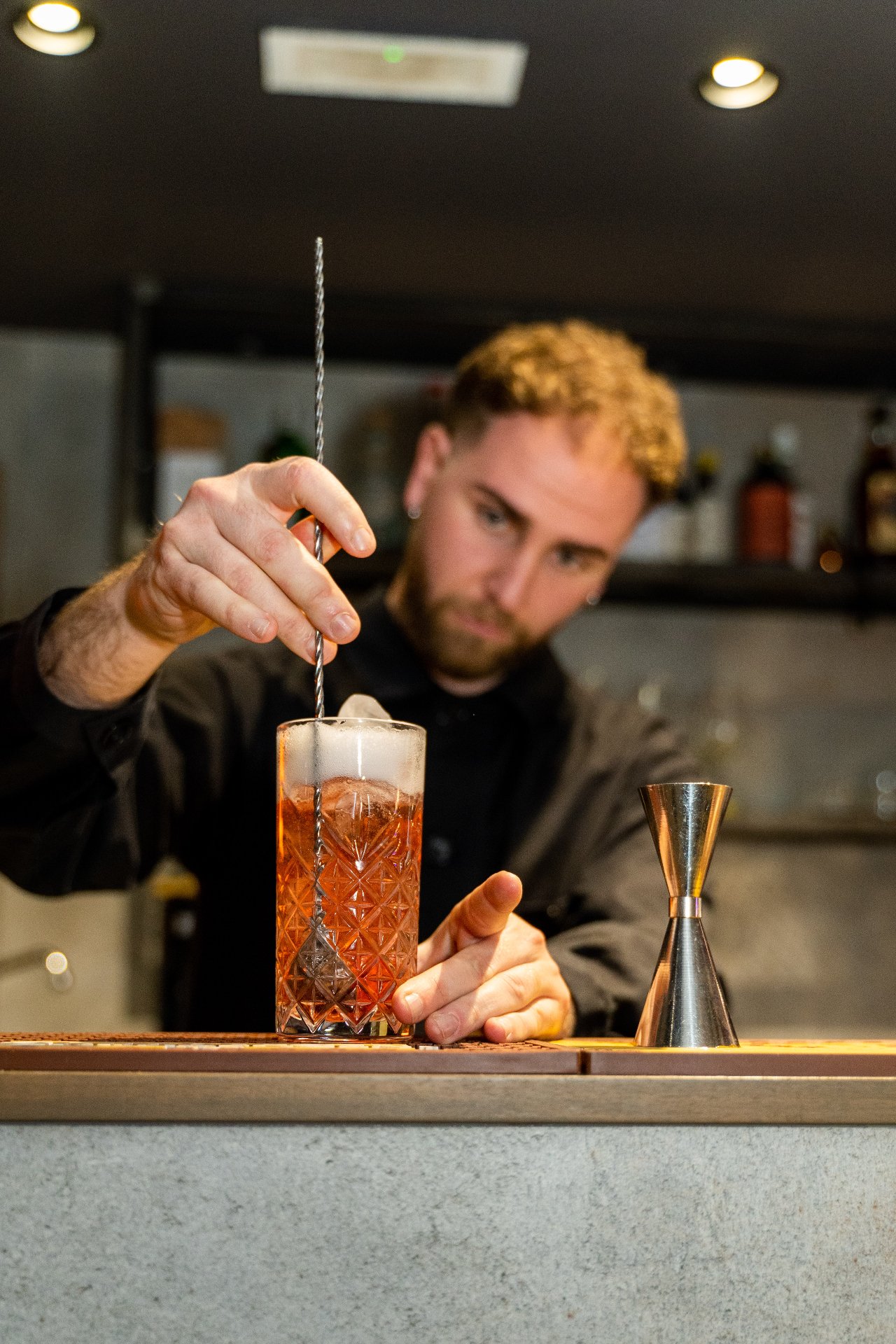 Bartender che prepara un cocktail al bancone